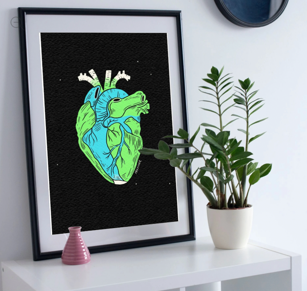 Earth Is A Heart Art Print by Fox Fisher - Framed anatomical heart earth print on white shelf with plant, modern home decor art
