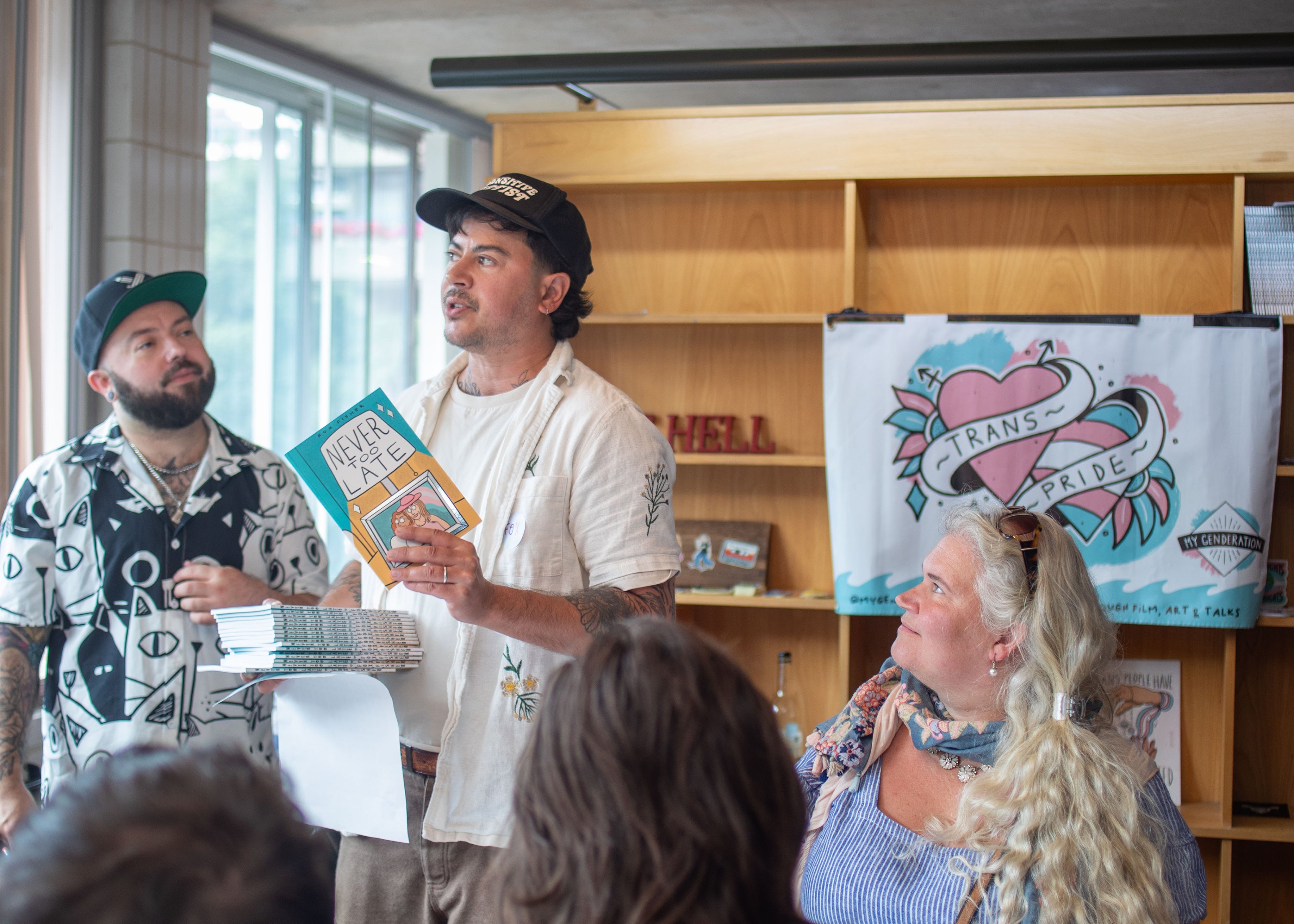 Group of people in a casual setting with one person holding a book.